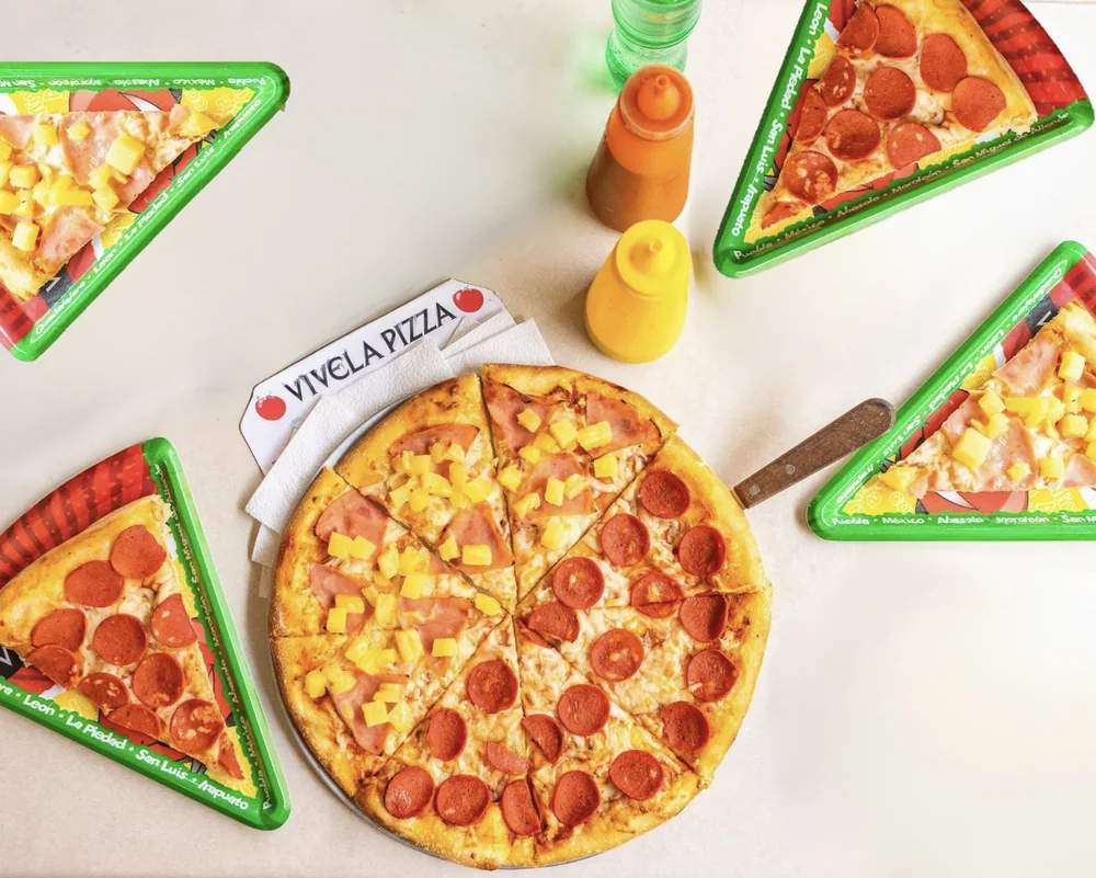 Pizzas Vivela sobre charolas con nombres de distintas ciudades