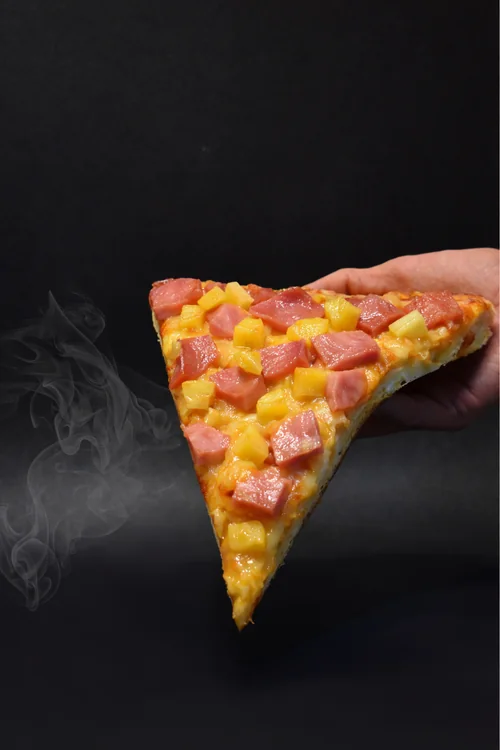 Rebanada de pizza hawaiana con jamón y piña
